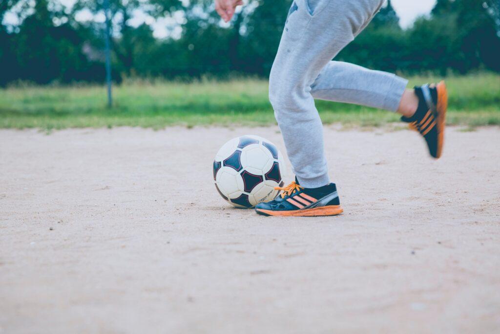 Kinderfüße spielen Fußball