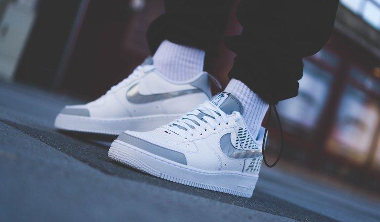 Person trägt weiße Nike Air Force 1 Low