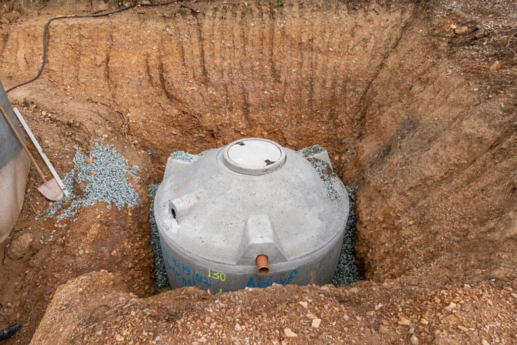 Betonzisterne wird in Erdgrube eingesetzt – Vorbereitung für Füllstandsanzeige Zisterne sichtbar