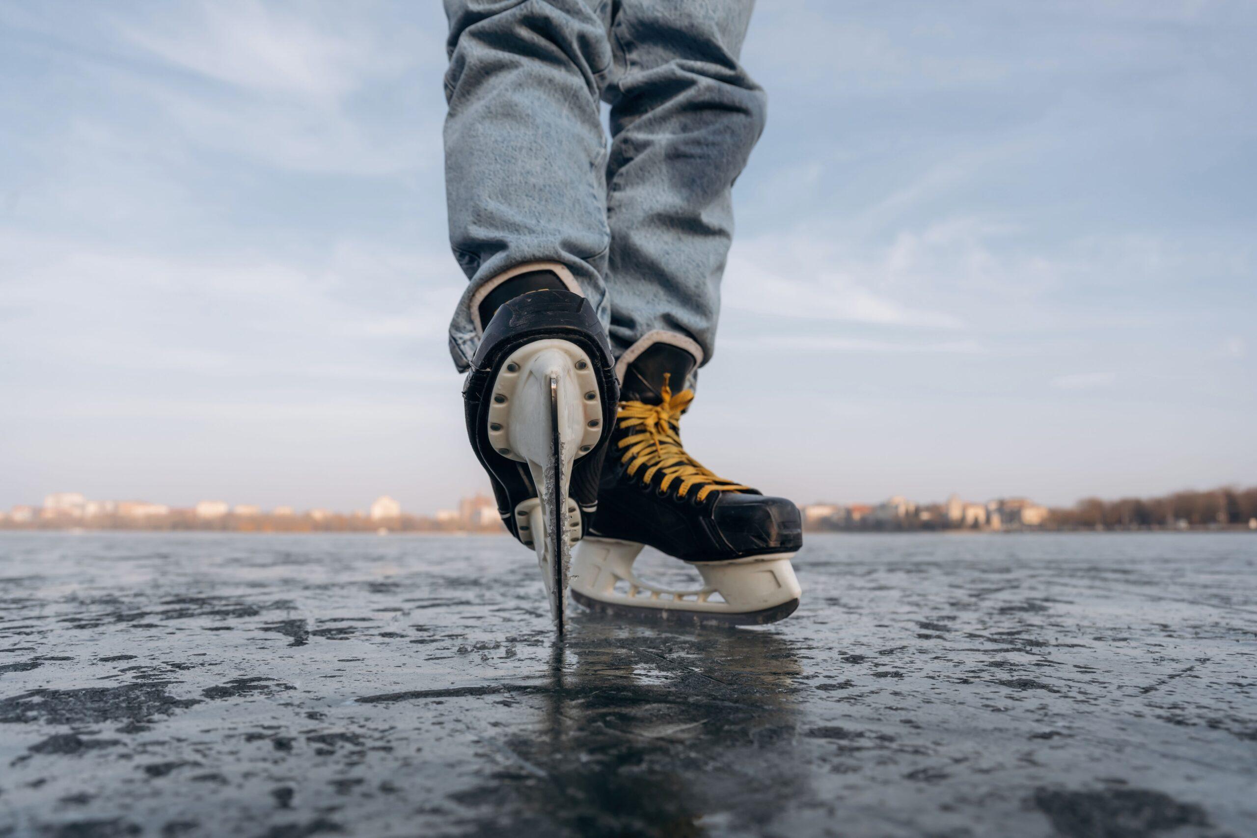 Schlittschuhe auf zugefrorenem See bei sicherem Stand, getragen von einer Person in Jeans