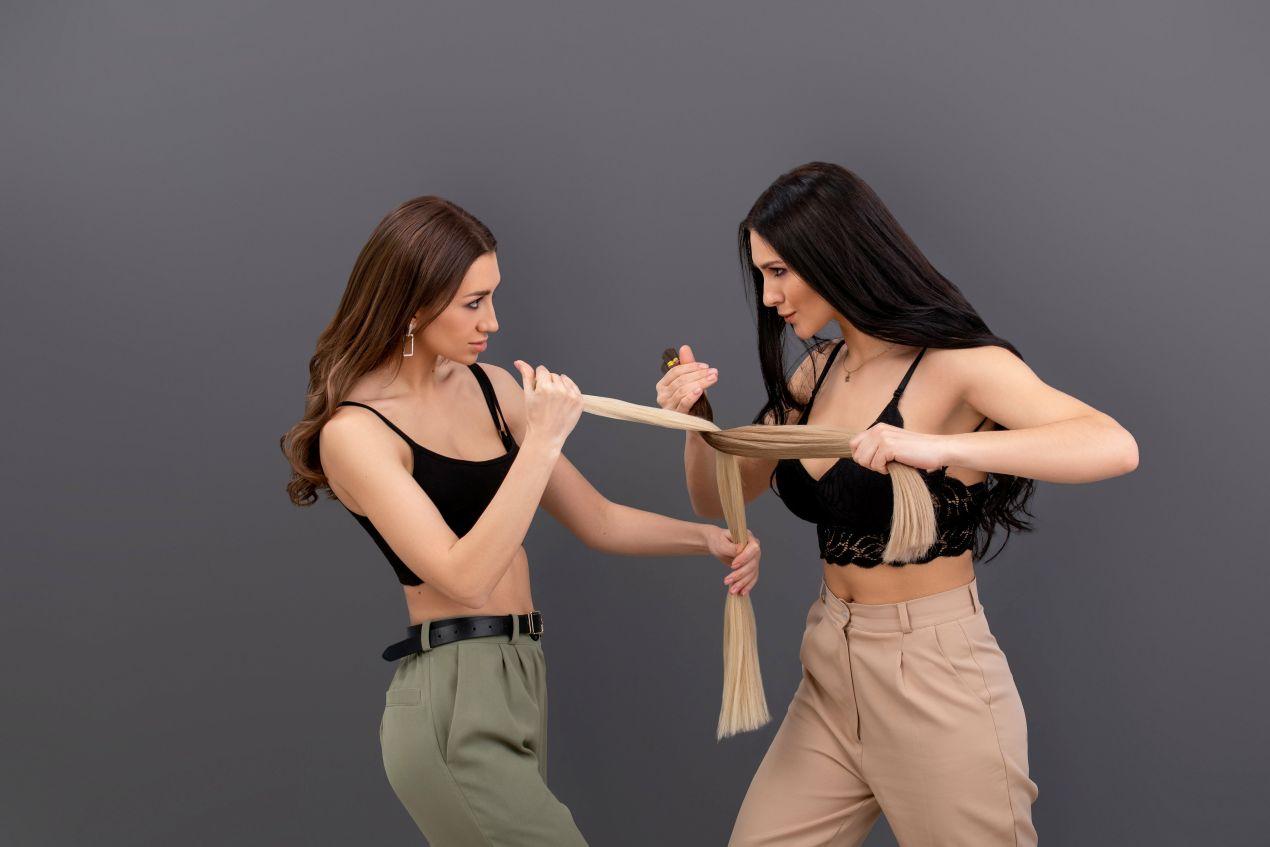 Zwei Frauen prüfen blonde Haarteile vor dem Anbringen – Entscheidungshilfe bei der Auswahl passender Ponytail Extensions für individuelles Styling