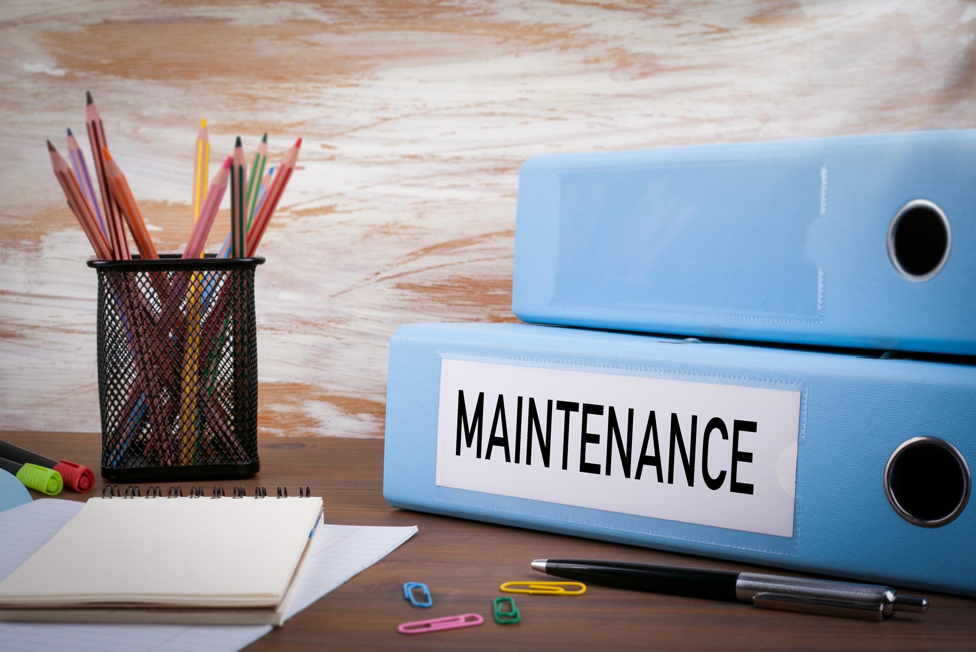 Ordner mit Aufschrift Maintenance auf Schreibtisch | Förderschläuche